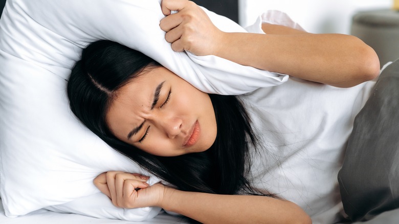 Woman struggling to get to sleep, big pillow