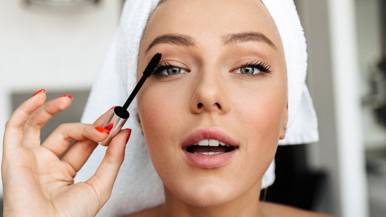 Woman putting mascara on