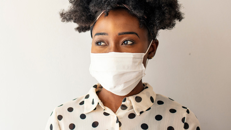 Woman wearing white mask with polka dot shirt