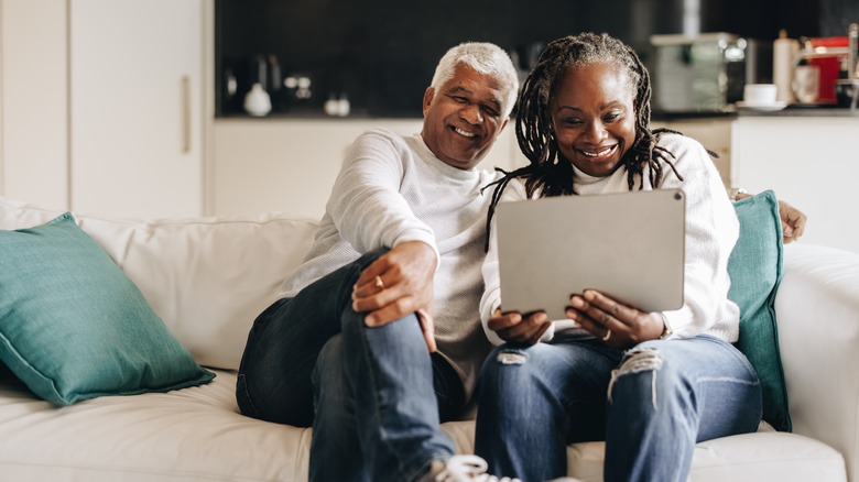 couple laughing at an ipad