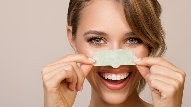 Woman wearing a pore strip before she rips it off