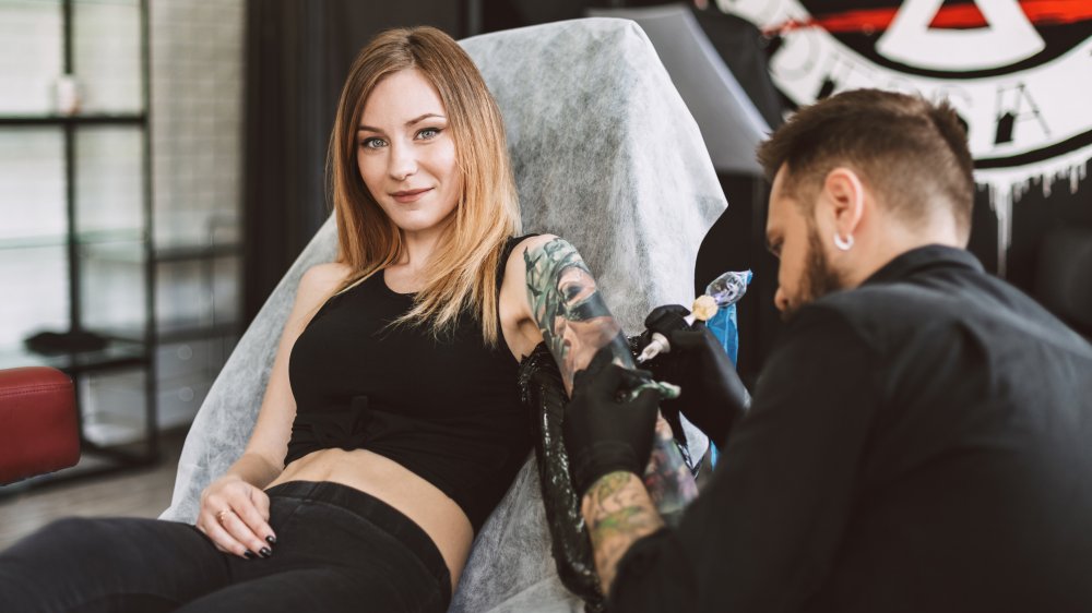 A woman getting tattooed by an artist
