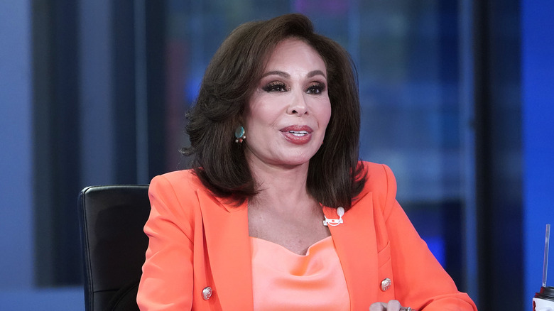Jeanine Pirro filming a broadcast in an orange suit