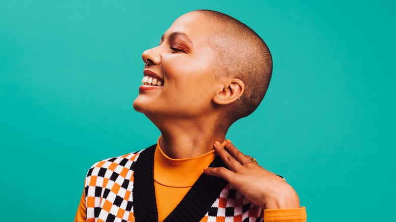 woman smiling and touching neck 