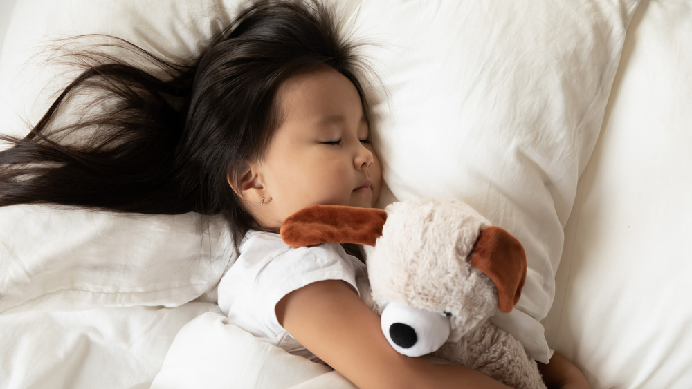 Girl sleeping with stuffed animal