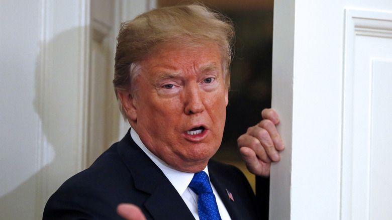 Donald Trump gestures to reporters at the Oval Office