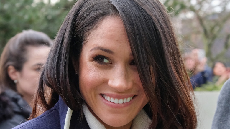 Meghan Markle smiling in coat 