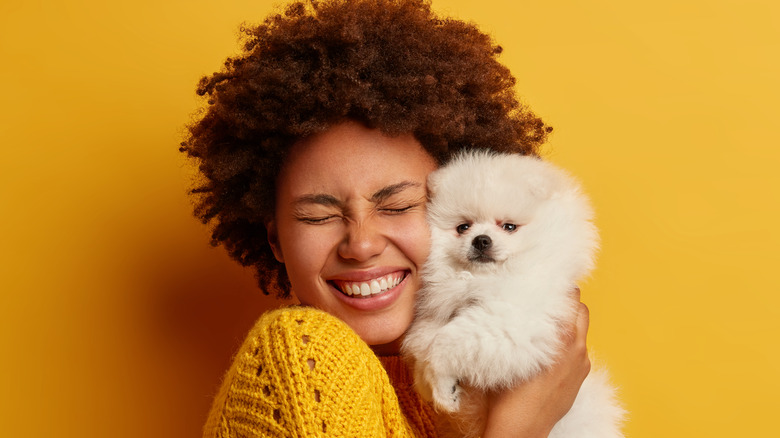 Woman cuddling a small dog