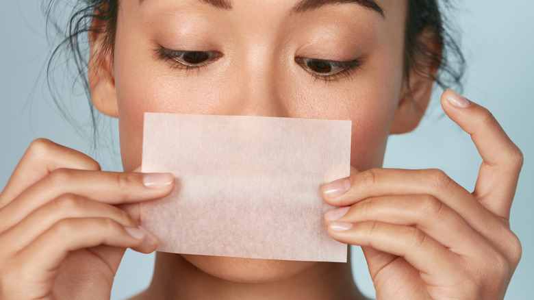 woman with oil blotting paper