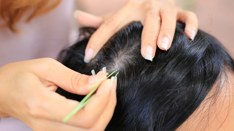 Woman plucking gray hair 