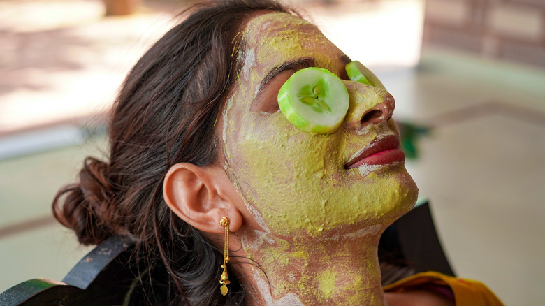 Woman with cucumber slices on eyes 