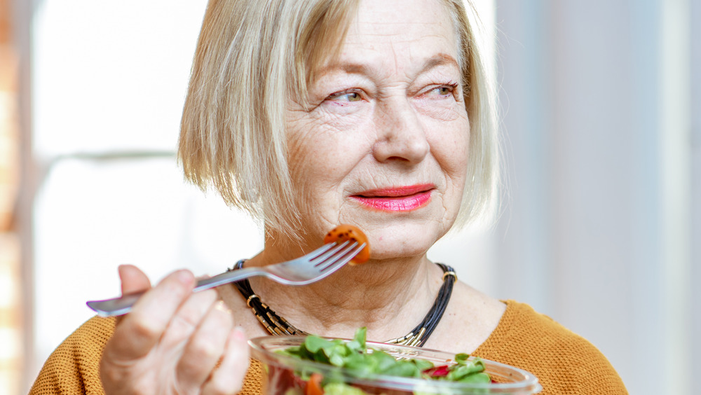 Older woman eating vegetables