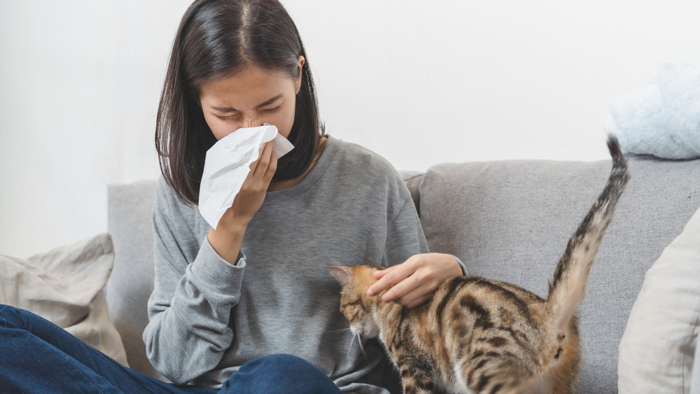 A congested woman blowing her nose