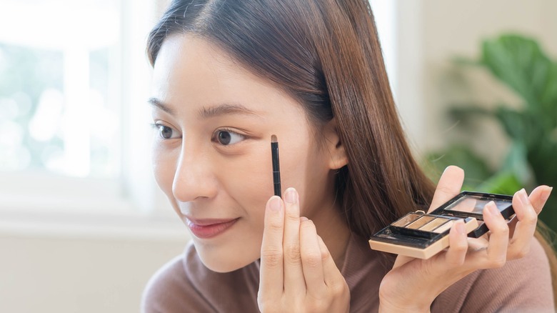 Woman doing eye makeup