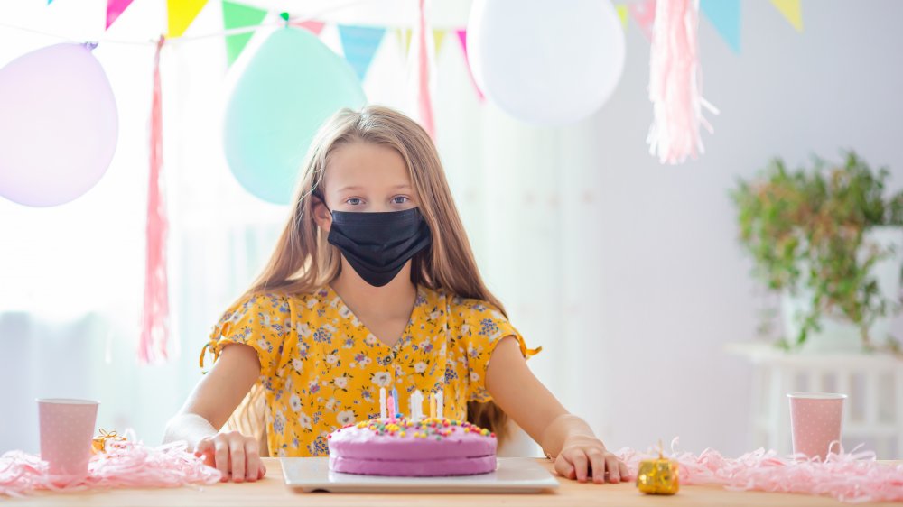 girl with mask and birthday cake