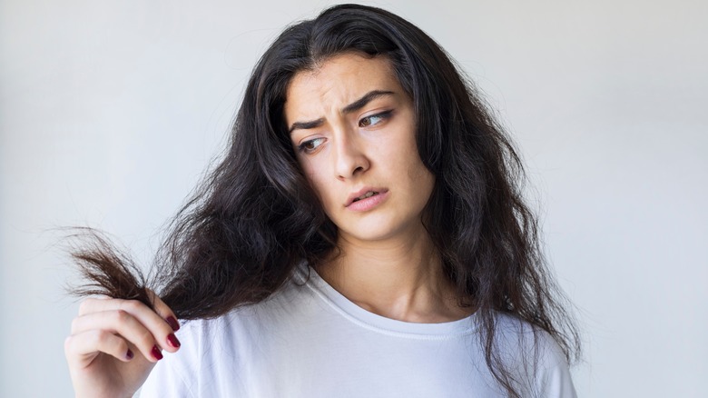 woman looking at damaged hair
