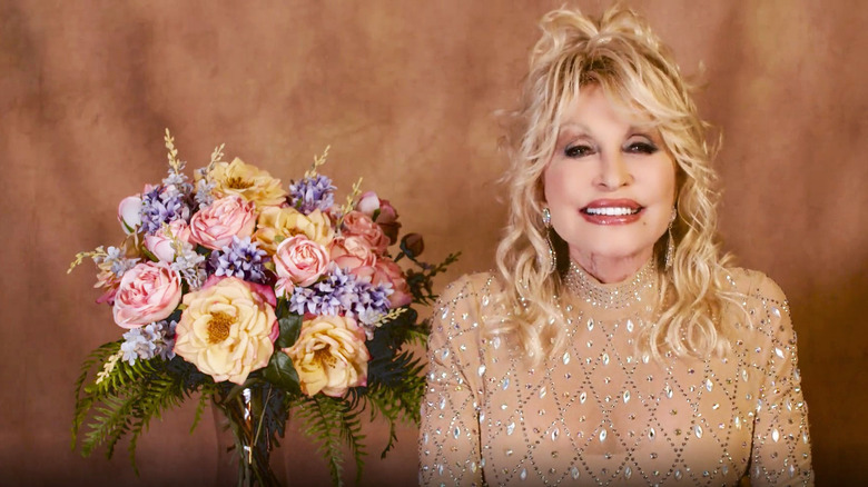 Dolly Parton posed next to flowers