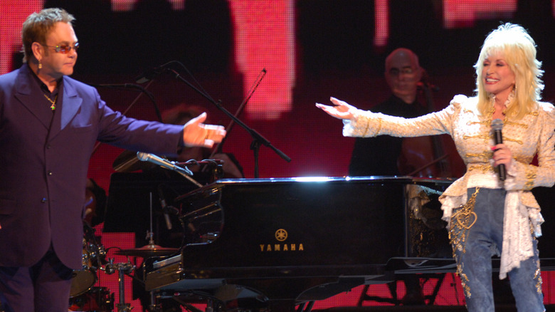 Dolly Parton and Elton John gesturing to each other on stage 2005