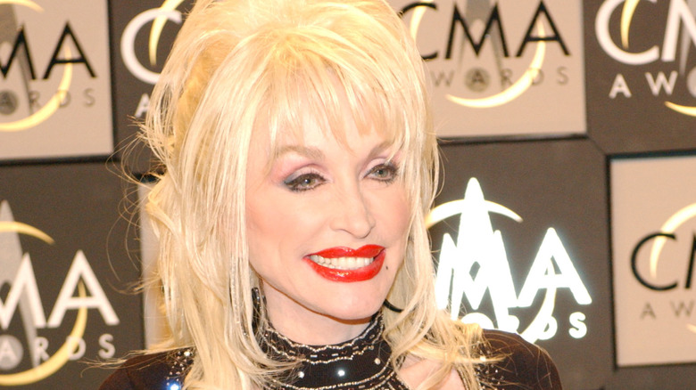 Dolly Parton smiling and wearing red lipstick