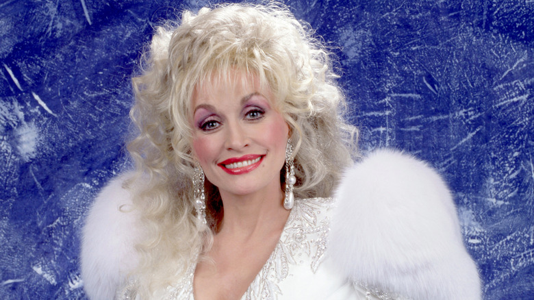 Dolly Parton smiling and wearing 80s-era shoulder pads