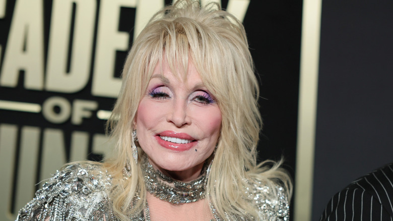 Dolly Parton smiling in a gold dress at the 58th Academy of Country Music Awards.