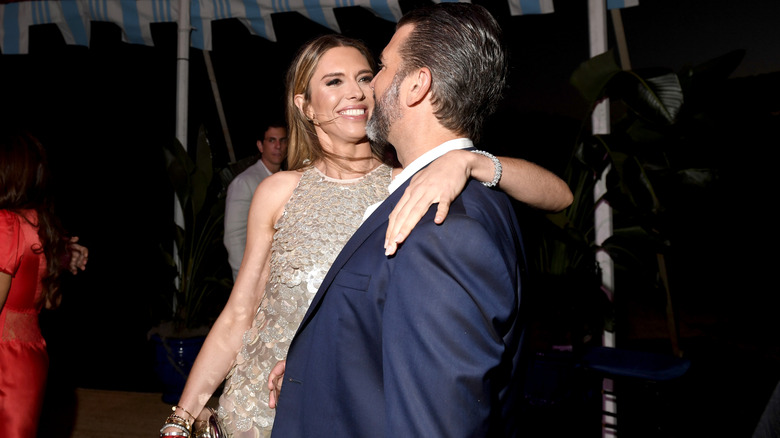 Bettina Anderson smiling in a sparkly dress with her arms around Donald Trump Jr.