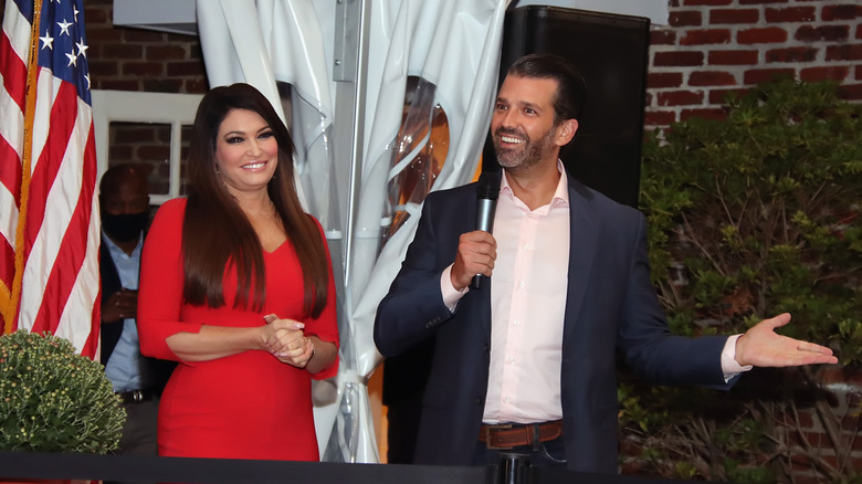 Kimberly Guilfoyle red dress Donald Trump Jr. microphone gesturing