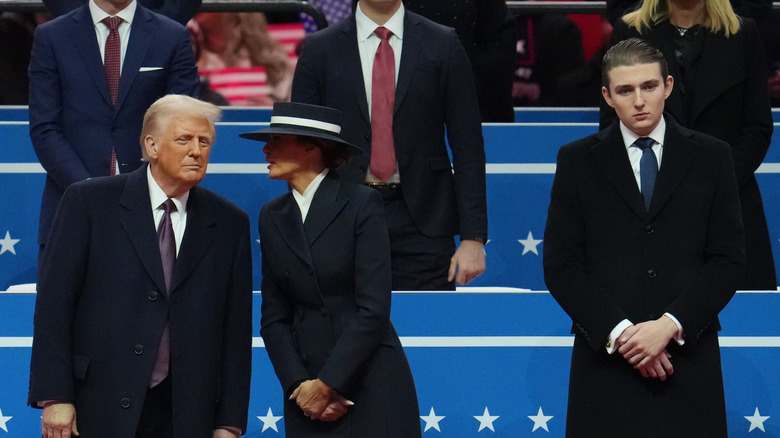Donald and Melania Trump talking and Barron standing apart inaugural parade