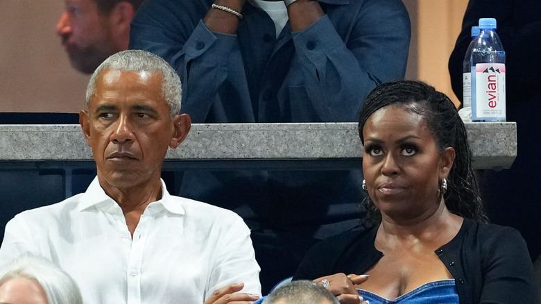 Barack Obama and Michelle Obama sitting next to each other at a tennis tournament.