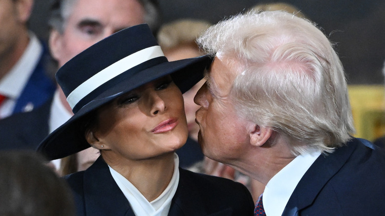 Melania Trump puckering up her lips as Donald Trump attempts to kiss her cheek