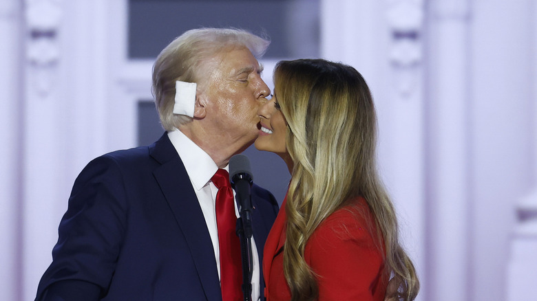 Melania Trump smiling as Donald Trump kisses her cheek