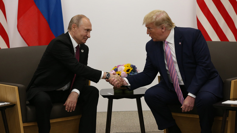 Vladimir Putin shakes Donald Trump's hand