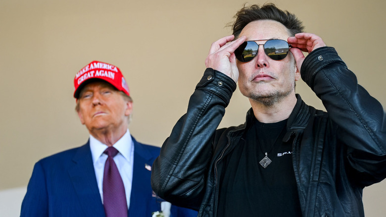 Elon Musk with Donald Trump standing behind him at a SpaceX launch