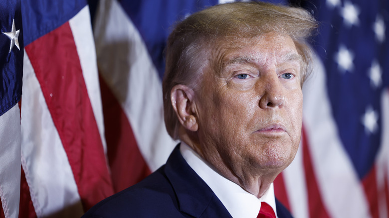 Donald Trump standing in front of U.S. flag