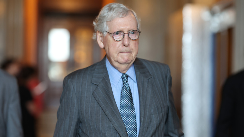Mitch McConnell looking serious and walking