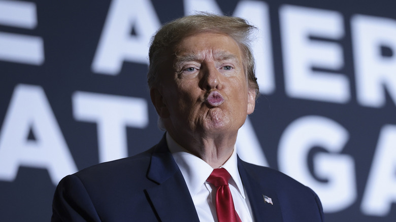 Donald Trump wearing a suit and blowing a kiss