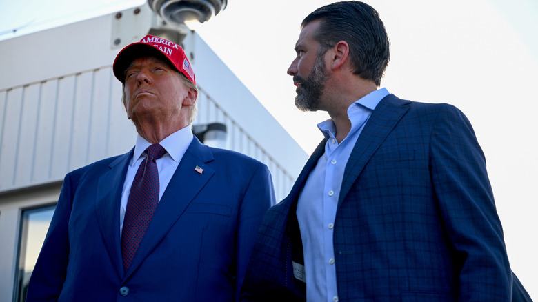 Donald Trump and Donald Trump Jr. standing next to each other in suits