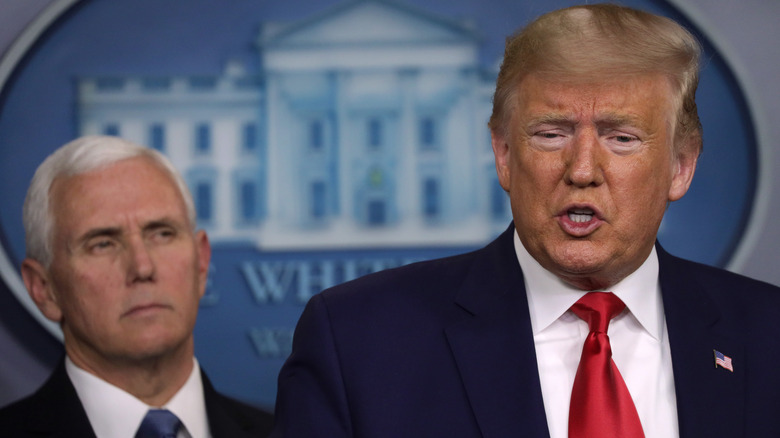 Donald Trump speaking with Mike Pence in the background