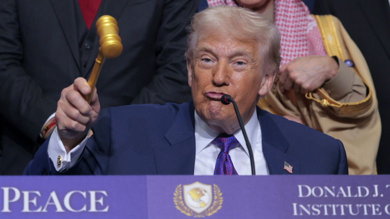 Donald Trump lifting a gavel at the first Board of Peace meeting