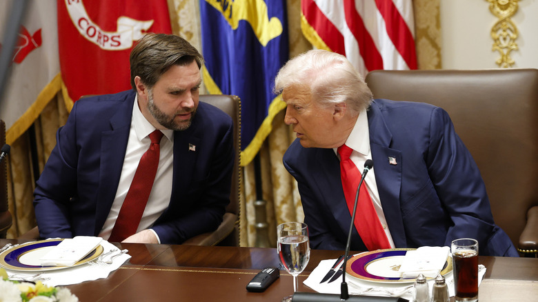 JD Vance and Donald Trump huddle together