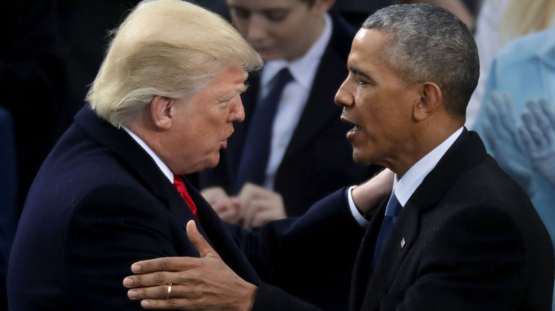 Donald Trump and Barack Obama grabbing each other by the shoulder
