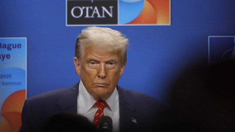 Donald Trump staring out over a crowd of people who block the camera.