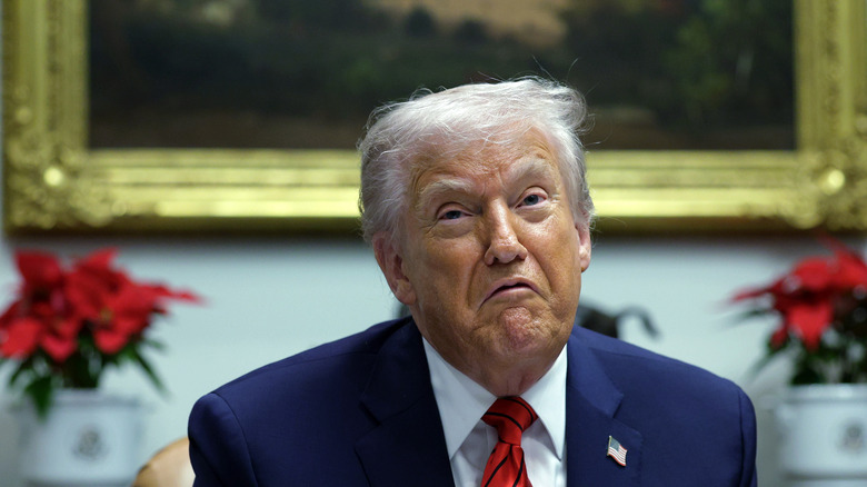 Donald Trump making an exaggerated pouting expression inside the White House