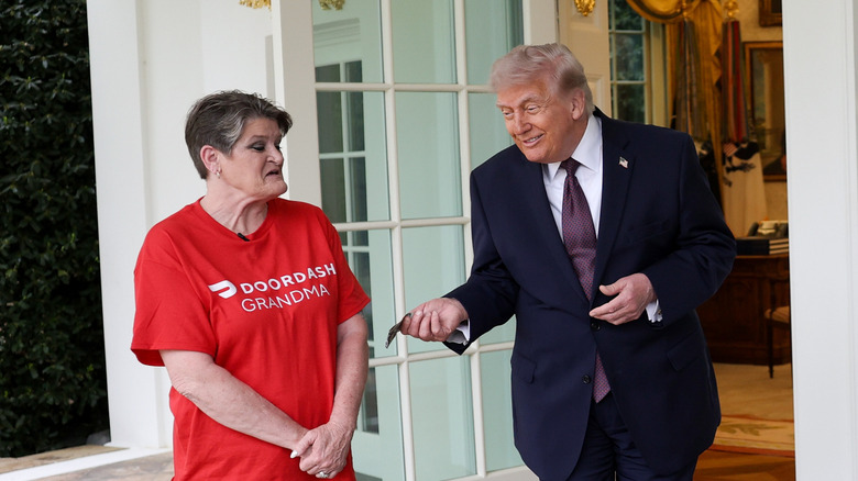 President Donald Trump tips Sharon Simmons after receiving a DoorDash delivery of McDonald's during an event outside the Oval Office of the White House on April 13, 2026 in Washington, DC.