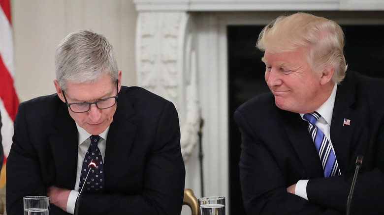 Tim Cook looks down as Donald Trump smiles at him in the State Dining Room of the White House June 19, 2017 in Washington, DC.