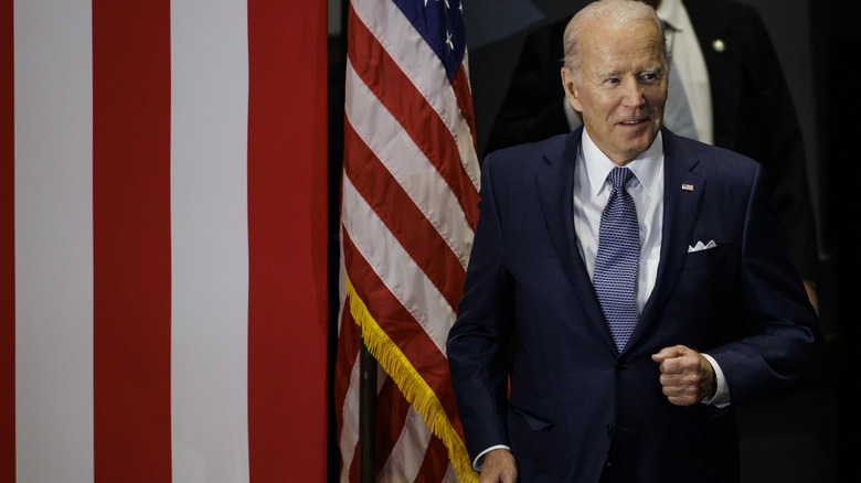 Joe Biden standing near an American flag