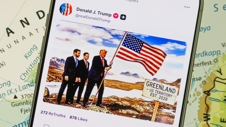 A phone showing Donald Trump's Truth Social post depicting an AI-generated image of Trump planting an American flag on Greenland