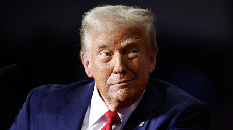 Donald Trump making a face in front of a black background