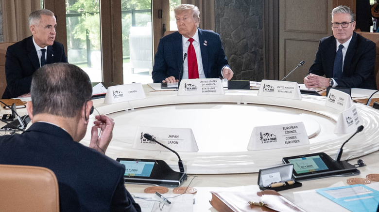 Donald Trump sitting between Canadian Prime Minister Mark Carney and British Prime Minister Keir Starmer at the G7 roundtable