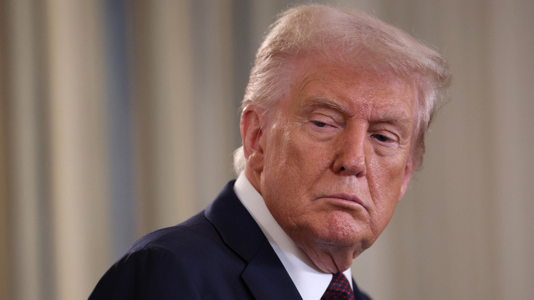 Donald Trump looking sad in a black suit
